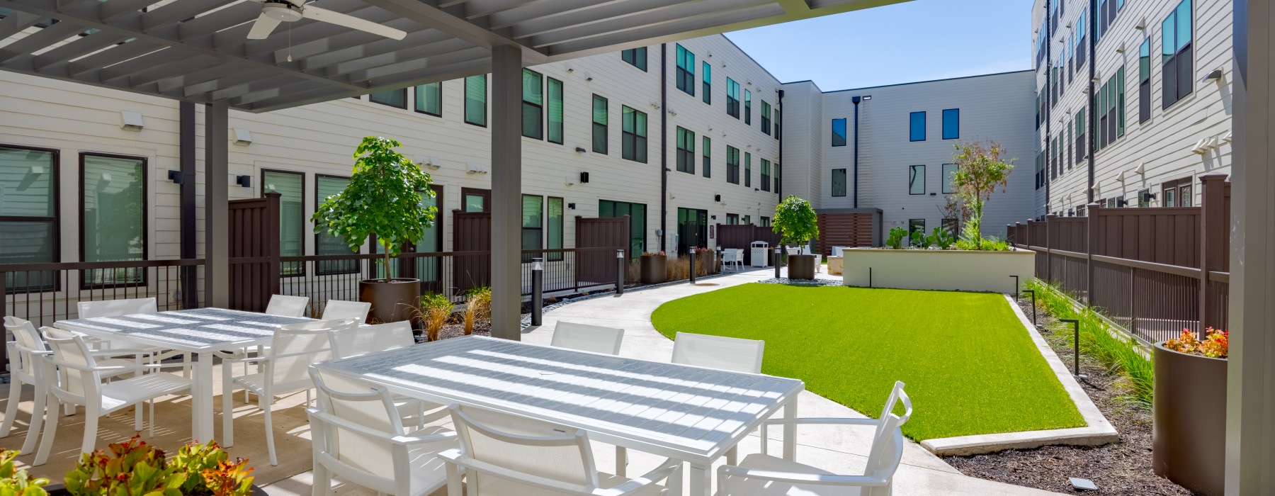 An outdoor Zen courtyard with seating, fire pit and lawn