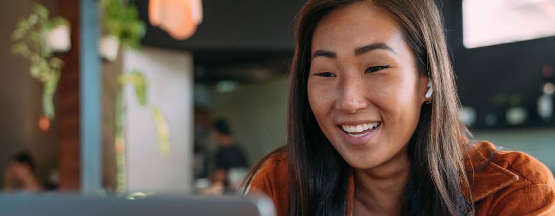 a woman smiling while working on laptop